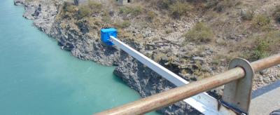 Simple water supply system using a suspended pipe over a river.